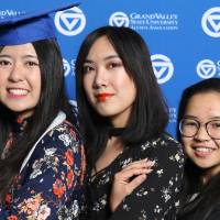 Three students pose for a photo at GradFest